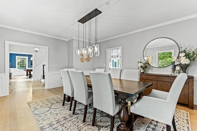 dining space with light hardwood / wood-style flooring and ornamental molding