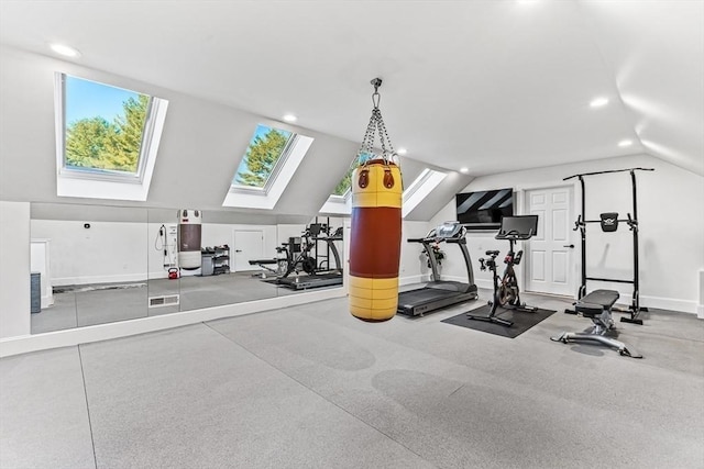 exercise area featuring vaulted ceiling with skylight