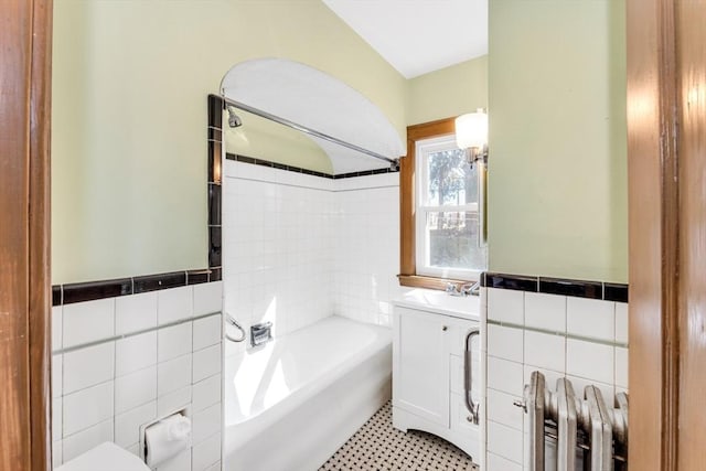 full bathroom featuring radiator, wainscoting, tile walls, and vanity