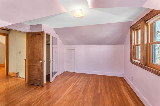 bonus room featuring vaulted ceiling, wood finished floors, and baseboards