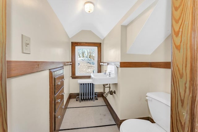 bathroom with toilet, baseboards, vaulted ceiling, and radiator heating unit