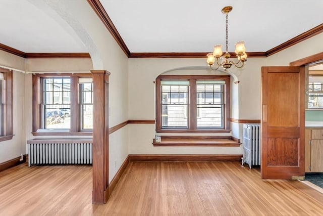 unfurnished dining area featuring light wood-style floors, plenty of natural light, and radiator