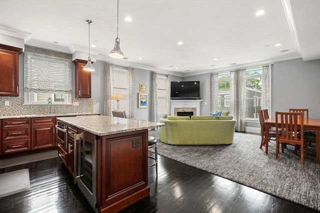615 E 6th St Unit 6, Boston, MA 02127 - kitchen with beverage cooler, a center island, dark wood-style floors, a fireplace, and a kitchen bar