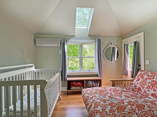 187 Plain Rd, Greenfield, MA 01301 - bedroom featuring a wall unit AC, lofted ceiling, multiple windows, a skylight, and wood finished floors