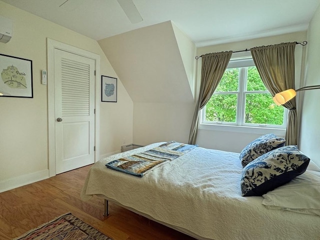 187 Plain Rd, Greenfield, MA 01301 - bedroom featuring wood finished floors, baseboards, a ceiling fan, a wall mounted air conditioner, and vaulted ceiling
