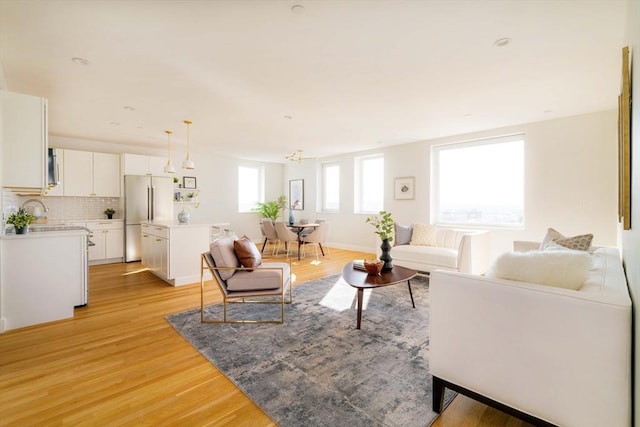 living room featuring sink and light hardwood / wood-style flooring