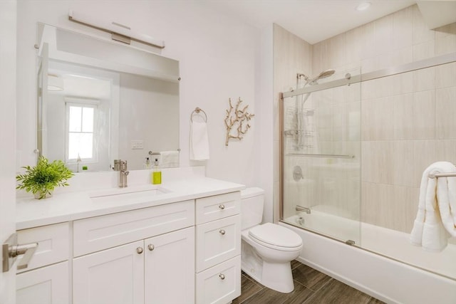 full bathroom featuring vanity, toilet, and combined bath / shower with glass door