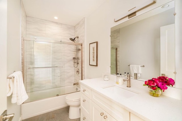 full bathroom featuring vanity, combined bath / shower with glass door, and toilet