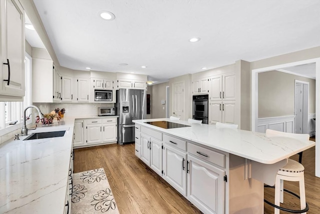 kitchen with light stone countertops, white cabinets, and stainless steel appliances