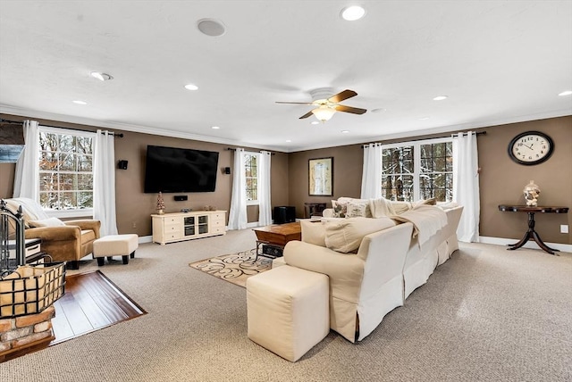 living room with ceiling fan, light colored carpet, and crown molding