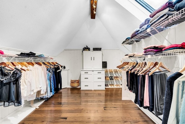 walk in closet with dark hardwood / wood-style floors and vaulted ceiling with beams