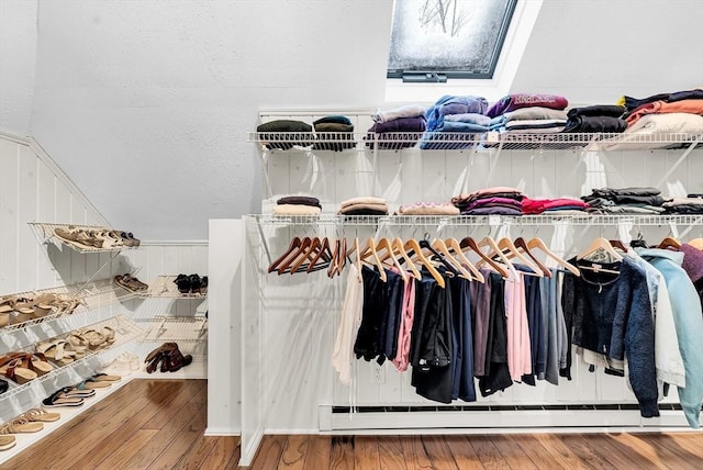 walk in closet with a baseboard radiator and wood-type flooring