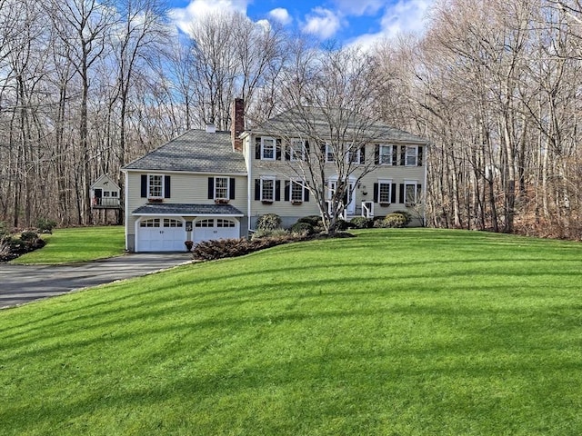 colonial-style house with a garage and a front lawn