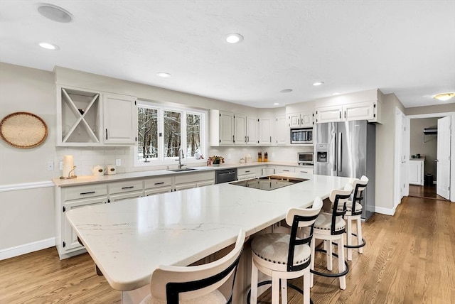 kitchen with black appliances, backsplash, a center island, and white cabinets