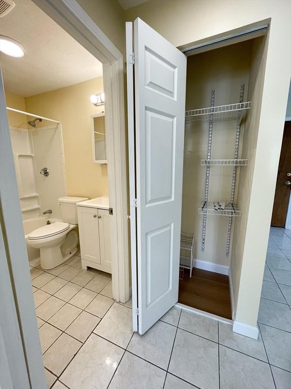 full bathroom with vanity, tile patterned flooring, shower / washtub combination, and toilet