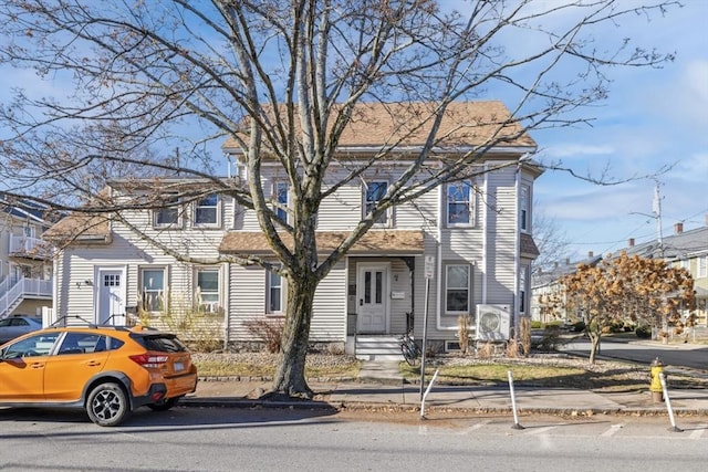 view of front of home with ac unit and a shingled roof