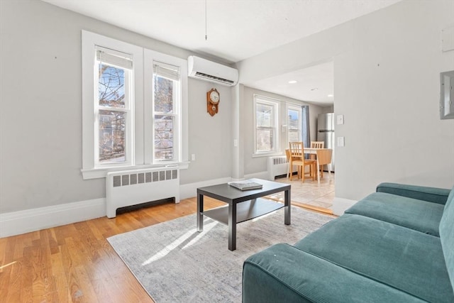 living room with an AC wall unit, radiator heating unit, wood finished floors, and baseboards