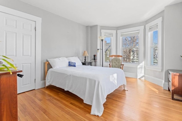 bedroom with baseboards and light wood finished floors