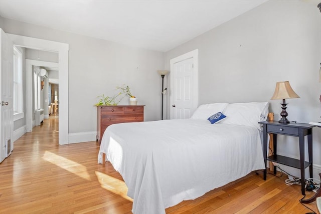 bedroom featuring radiator and light hardwood / wood-style floors