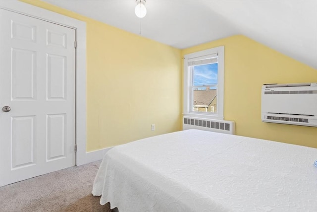 carpeted bedroom with radiator heating unit, a wall mounted AC, and lofted ceiling