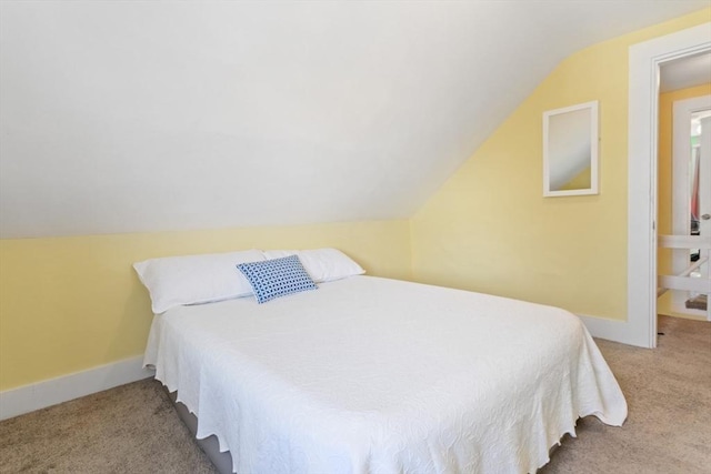 bedroom featuring carpet floors, lofted ceiling, and baseboards