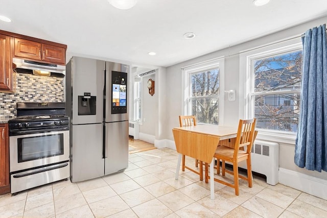 kitchen with stainless steel appliances, radiator, under cabinet range hood, and tasteful backsplash