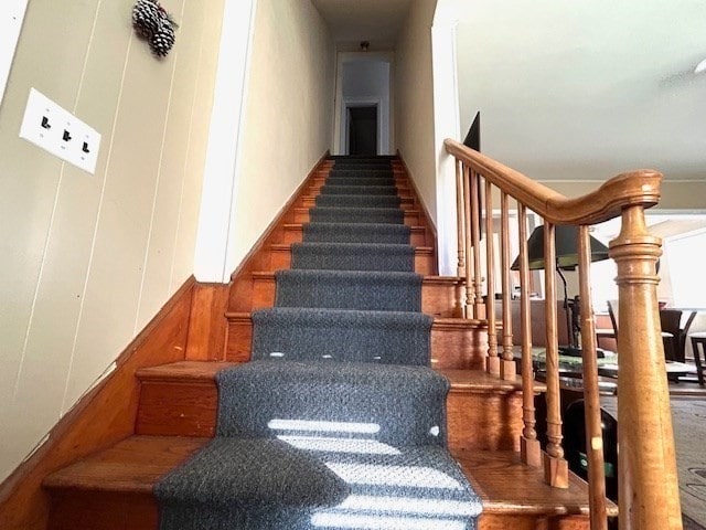 stairs with hardwood / wood-style floors and wooden walls