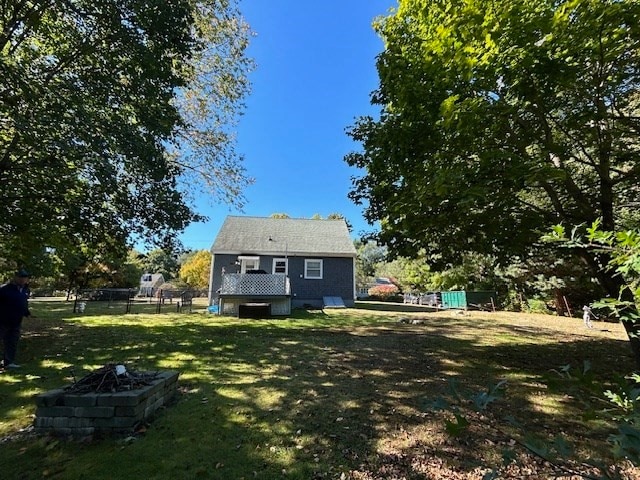 back of property featuring a yard and a fire pit