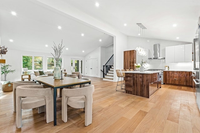 dining area with vaulted ceiling and light hardwood / wood-style flooring