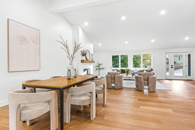 dining room with vaulted ceiling with beams and light wood-type flooring