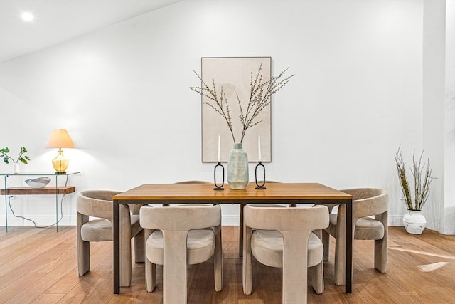 dining space with lofted ceiling and light hardwood / wood-style floors