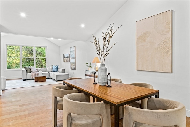 dining space featuring lofted ceiling and light hardwood / wood-style floors