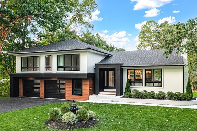 view of front of house featuring a front lawn and a garage