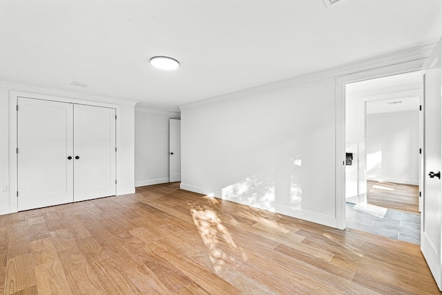 unfurnished bedroom with light wood-type flooring and ornamental molding