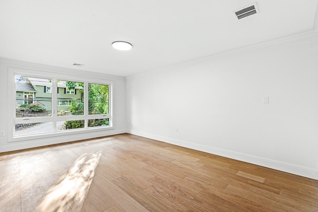 unfurnished room featuring light hardwood / wood-style floors and crown molding