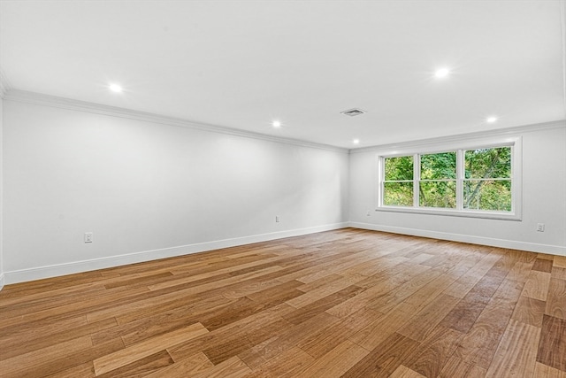 spare room featuring ornamental molding and light hardwood / wood-style flooring