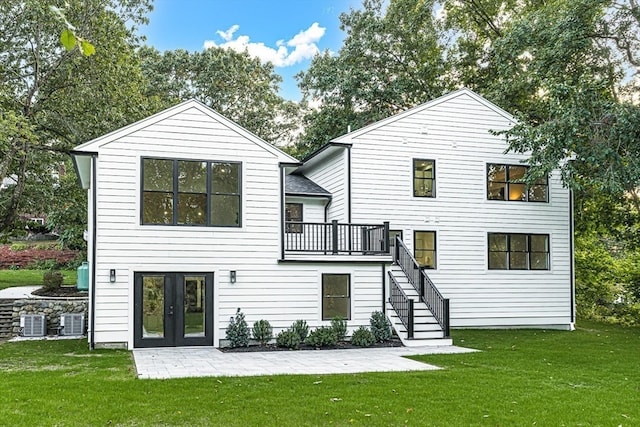 rear view of house with a lawn, central AC, and a patio area