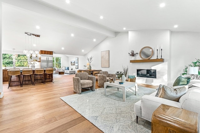 living room featuring lofted ceiling with beams and light hardwood / wood-style flooring