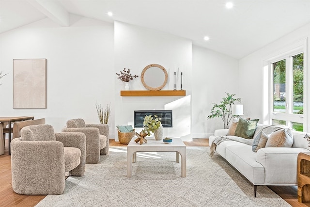 living room featuring light hardwood / wood-style flooring, beam ceiling, and high vaulted ceiling