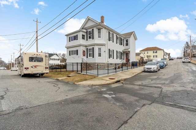 view of front of home with a fenced front yard and a chimney