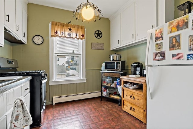 kitchen with white cabinets, wainscoting, appliances with stainless steel finishes, brick floor, and baseboard heating