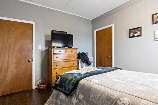 bedroom with dark wood-style floors and crown molding