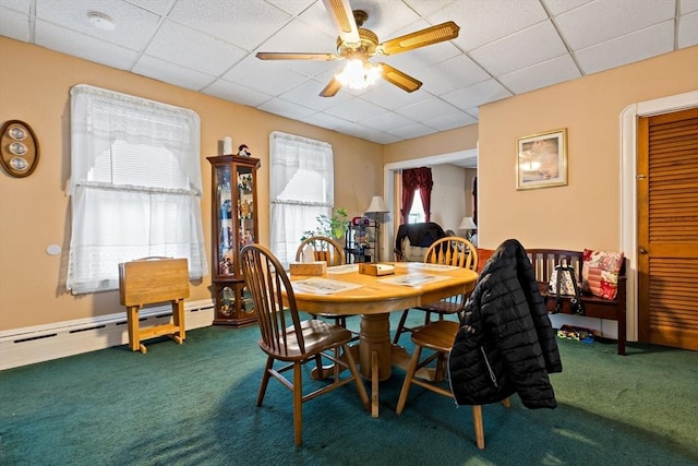 dining space with a drop ceiling, baseboard heating, carpet, and a ceiling fan