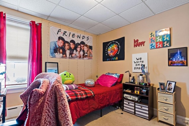 carpeted bedroom featuring a baseboard radiator and a drop ceiling