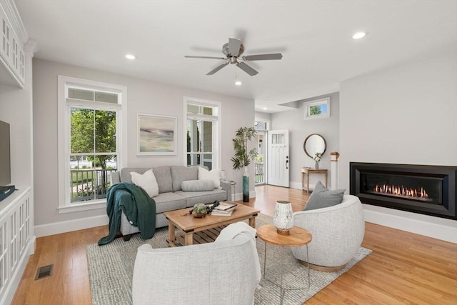 15 Boydes Xing Unit 13, Norfolk, MA 02056 - living area with baseboards, light wood-style flooring, a glass covered fireplace, a ceiling fan, and recessed lighting