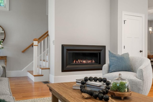 15 Boydes Xing Unit 13, Norfolk, MA 02056 - living room featuring wood finished floors, stairs, baseboards, and a warm lit fireplace