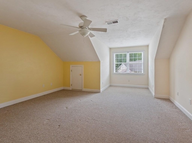 bonus room featuring light carpet, vaulted ceiling, ceiling fan, and baseboards