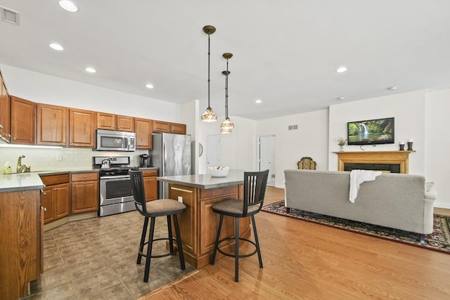 28 Summerfield Dr Unit 28, Grafton, MA 01560 - kitchen with appliances with stainless steel finishes, a center island, a breakfast bar, a sink, and decorative backsplash