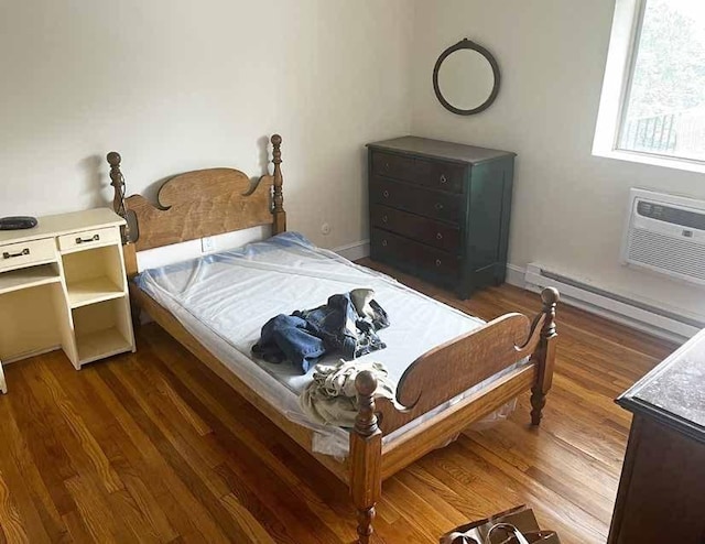 447 Pleasant St, Melrose, MA 02176 - bedroom with a wall mounted air conditioner, a baseboard radiator, wood finished floors, and baseboards