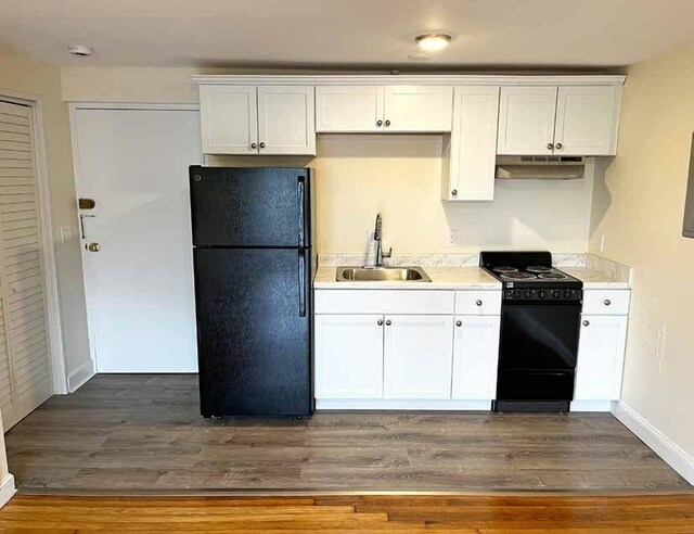 447 Pleasant St, Melrose, MA 02176 - kitchen featuring black appliances, a sink, under cabinet range hood, light countertops, and white cabinets
